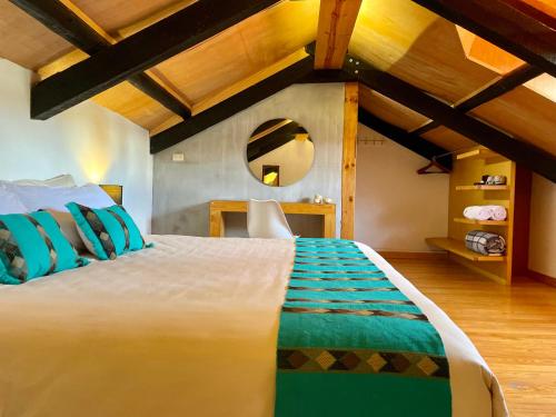 una camera da letto con un grande letto bianco e uno specchio di Hotel Casa Azabache a San Cristóbal de Las Casas