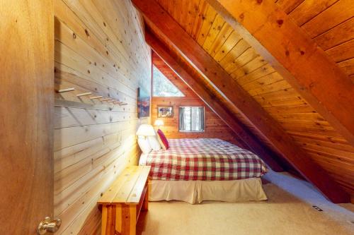 a small attic room with a bed and a bench at Tahoe Pines Cabin in Homewood