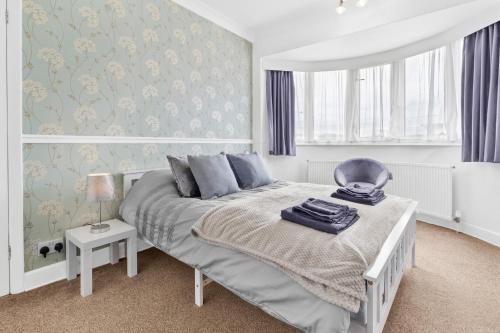 een slaapkamer met een bed en een blauwe en witte muur bij Spacious 4 Bedroom House located near NEC, BHX & HS2 in Solihull