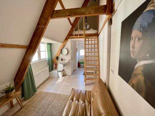 a living room with a painting of a woman on the wall at Tiny Private City Rooms Haarlem in Haarlem