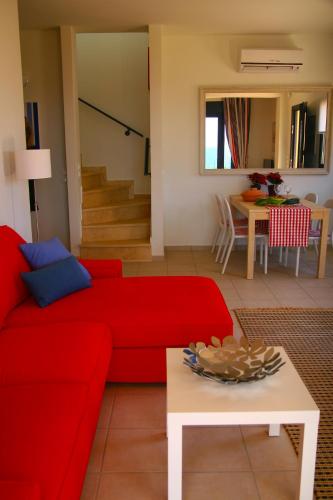 a living room with a red couch and a table at Villa Brio Exclusive in Skala Kefalonias