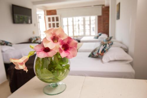 a vase with flowers on a table in a bedroom at Alojamiento Turístico Verano Azul San Andrés in San Andrés