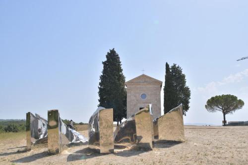 a building with a clock tower in the middle of a field at 42 Vacanza di relax in Maremma - wifi - free parking in Castel del Piano