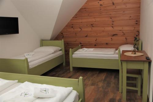 Habitación pequeña con 2 camas y mesa. en Aparthotel Mádr, en Modrava