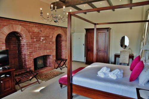 a bedroom with a bed and a fireplace at Wild Mushroom Country House in Stellenbosch