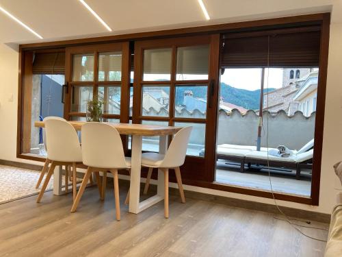 una sala da pranzo con tavolo, sedie e una grande finestra di Apartamento céntrico con WIFI y climatizado de 1 habitación y sofá-cama para 3 personas a Santa Coloma de Farners