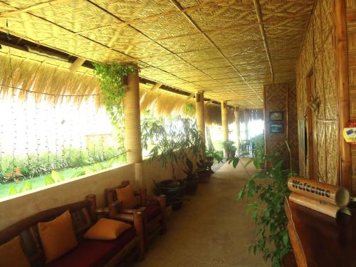 a hallway with chairs and plants in a building at DACOZY Beach Resort in Moalboal