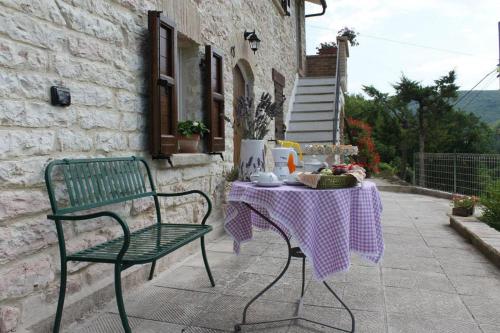 a table and a green chair and a table with a purple table cloth at B&B Il Poggetto in Serra SantʼAbbondio