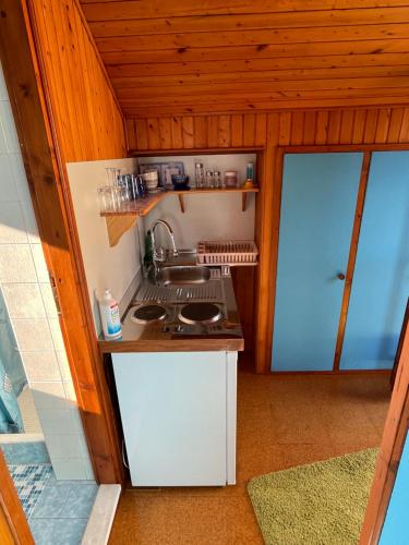 a small kitchen with a sink and a stove at Perun Guest House in Mlini