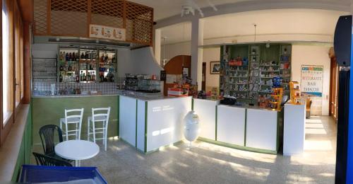a store with a counter with stools in a room at Albergo casa del turista in Torre dell'Orso