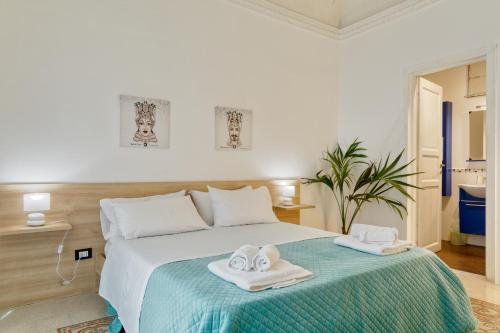una camera da letto con un letto e asciugamani di Sicilian Rooms Palermo a Palermo