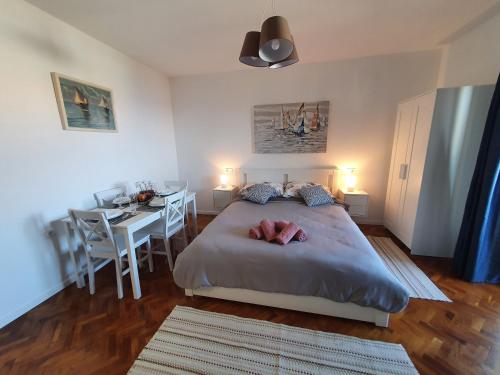 een slaapkamer met een bed en een tafel met stoelen bij Studio Apartman Fredi in Opatija