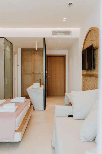 two beds in a room with a sink and a bathroom at Abonora Drymades in Dhërmi