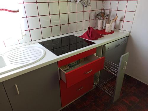 een keuken met een wastafel en een rode lade bij CozyPlace in Zadar