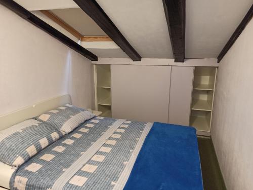 een kleine slaapkamer met een bed en een witte kast bij CozyPlace in Zadar