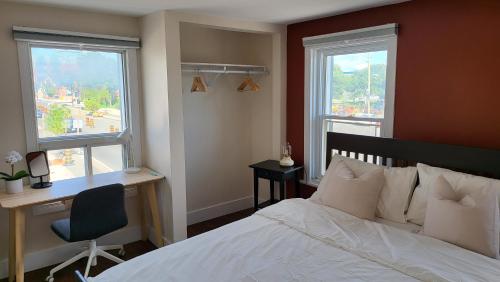 um quarto com uma cama, uma secretária e 2 janelas em JstLikeHome - Old Ottawa em Ottawa