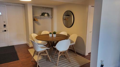 a dining room with a wooden table and white chairs at JstLikeHome - Old Ottawa in Ottawa