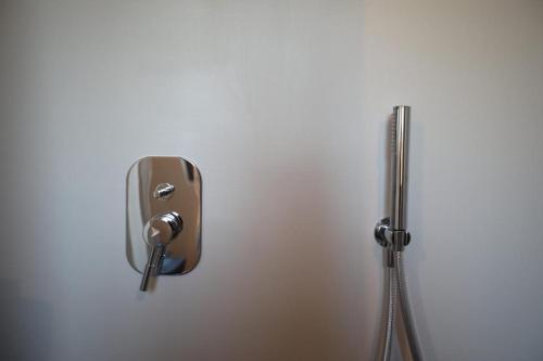 a dispenser on a wall next to a shower at CASA ADELE 1 per una vacanza in semplicità e relax in prossimità di Sperlonga in Itri