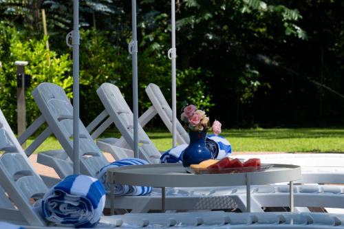 a table with a vase of flowers and fruit on it at Buxus Hotel Shekvetili in Shekvetili