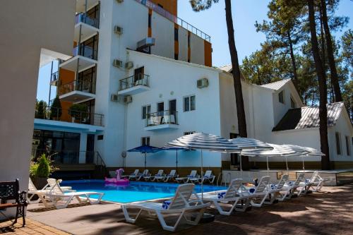 um hotel com piscina, cadeiras e guarda-sóis em Buxus Hotel Shekvetili em Shekhvetili