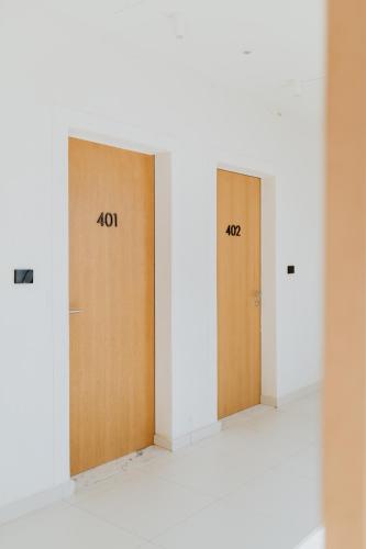 two brown doors in a white room with numbers on them at Abonora Drymades in Dhërmi