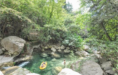 Un homme est debout dans une rivière avec un radeau dans l'établissement Nice Home In Saint-Jeannet With Wifi, à Saint-Jeannet