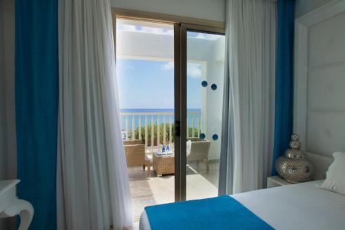 a bedroom with a bed and a view of the ocean at Althea Kalamies Luxury Villas in Protaras