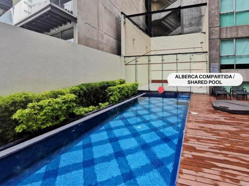 a swimming pool in front of a building at Centric Alure Apartments in Mexico City