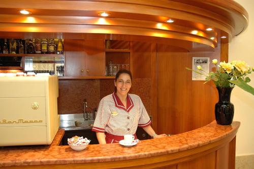 a woman standing behind a counter in a kitchen at Hotel Da Bruno in Venice