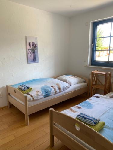 1 dormitorio con 2 camas y ventana en Hofgut Wollin GmbH en Putgarten