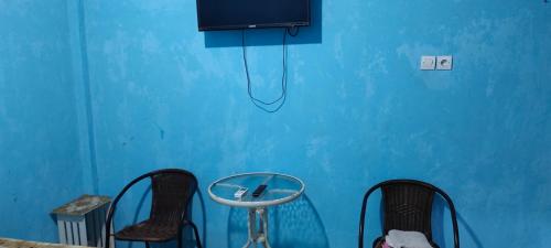 a blue room with two chairs and a tv at Hotel Near Ramayana 3 in Pekalongan