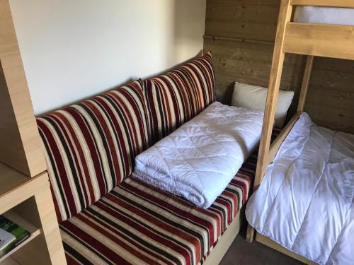 - un canapé dans un dortoir avec des lits superposés dans l'établissement Appartement aux pieds des pistes la tania courchevel, à La Perrière