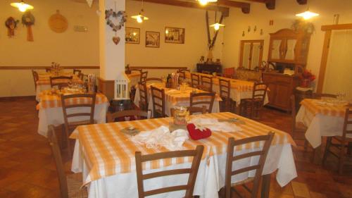 a dining room with tables with orange and white tablecloths at Al Castello in Artegna