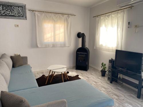uma sala de estar com um sofá e um fogão em Ain Draham sejour, maison duplex privé,seulement familles!!! netflix, Youtube em Aïn Draham