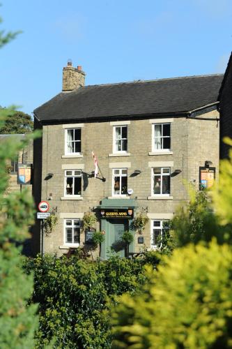 a large brick building with a green door at Queens arms country inn in Glossop