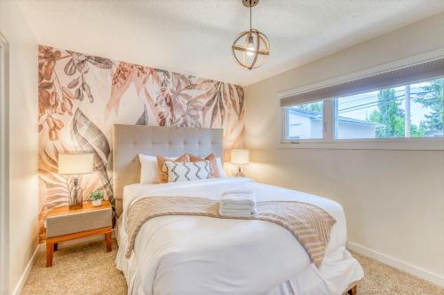 a bedroom with a large bed and a window at Luxury Home By North Glenmore Park in Calgary