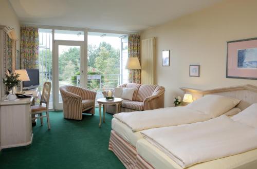 バート・ビルンバッハにあるHaus am Kurparkのベッド2台とリビングルームが備わるホテルルームです。