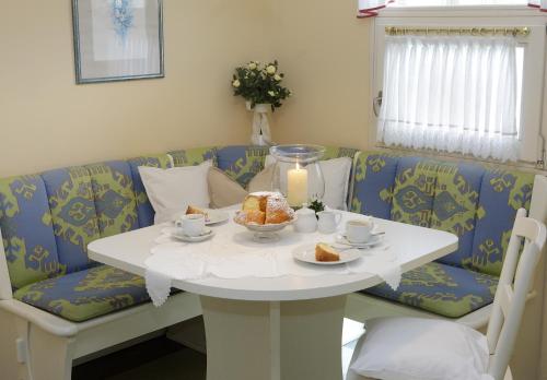 a white table with a cake and a candle on it at Haus am Kurpark in Bad Birnbach