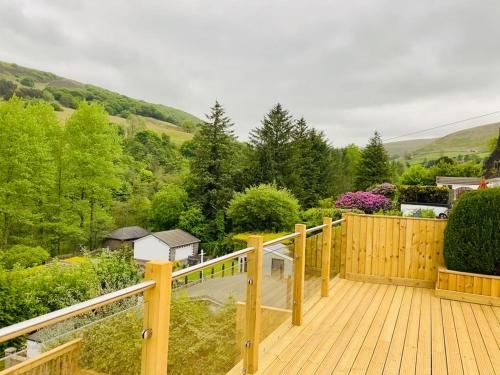 a wooden deck with a view of a valley at Lakeside View With Hot Tub in Abertillery