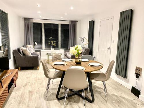 a living room with a wooden table and chairs at Lakeside View With Hot Tub in Abertillery