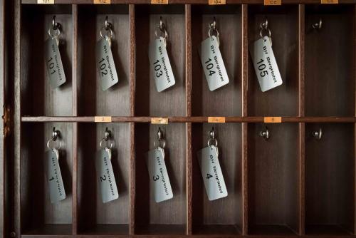 a bunch of tags hanging on a wooden wall at Berghotel in Bergamo