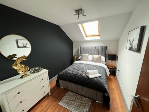 a bedroom with a bed with a mirror and a dresser at Luxury Belfast Stay in Belfast