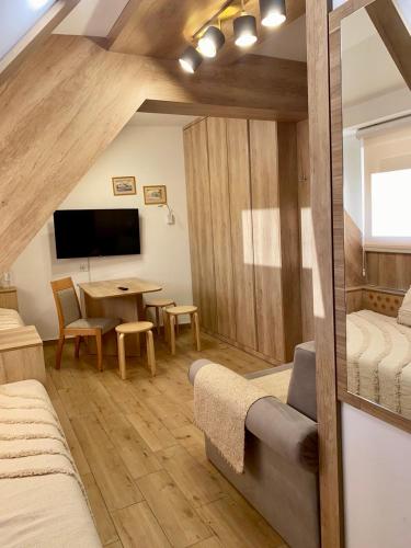 コパオニクにあるNevSki Apartmentsのベッドとダイニングテーブルが備わる客室です。
