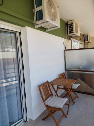 a dining room with a table and chairs and a window at Loutraki vibes apartments in Loutraki