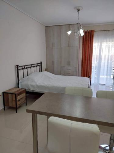 a bedroom with a bed and a table and chairs at Loutraki vibes apartments in Loutraki