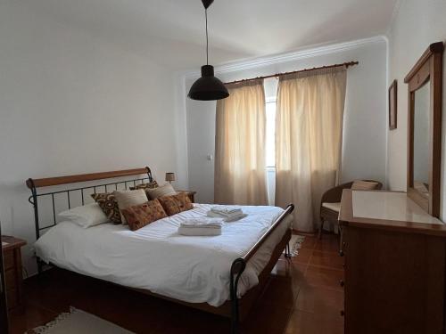 a bedroom with a bed and a desk and a window at Azenhas Apartment in Sintra