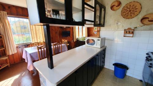 a kitchen with a counter top with a microwave at La Casa del Tata, El Quisco in El Quisco