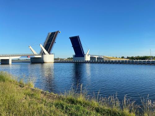 a bridge over a river with a bridge in the background at Villa Arkodes in Gdańsk
