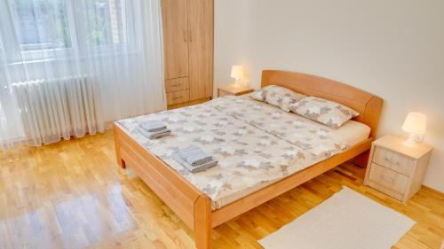 a bedroom with a bed with two lamps on it at MILICA 65m2, Free parking & Wi-fi in Novi Sad