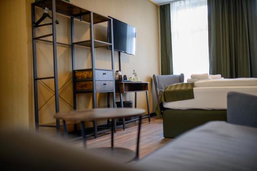une chambre d'hôtel avec un lit, une table et une chaise dans l'établissement Stadthotel König Albert, à Zittau